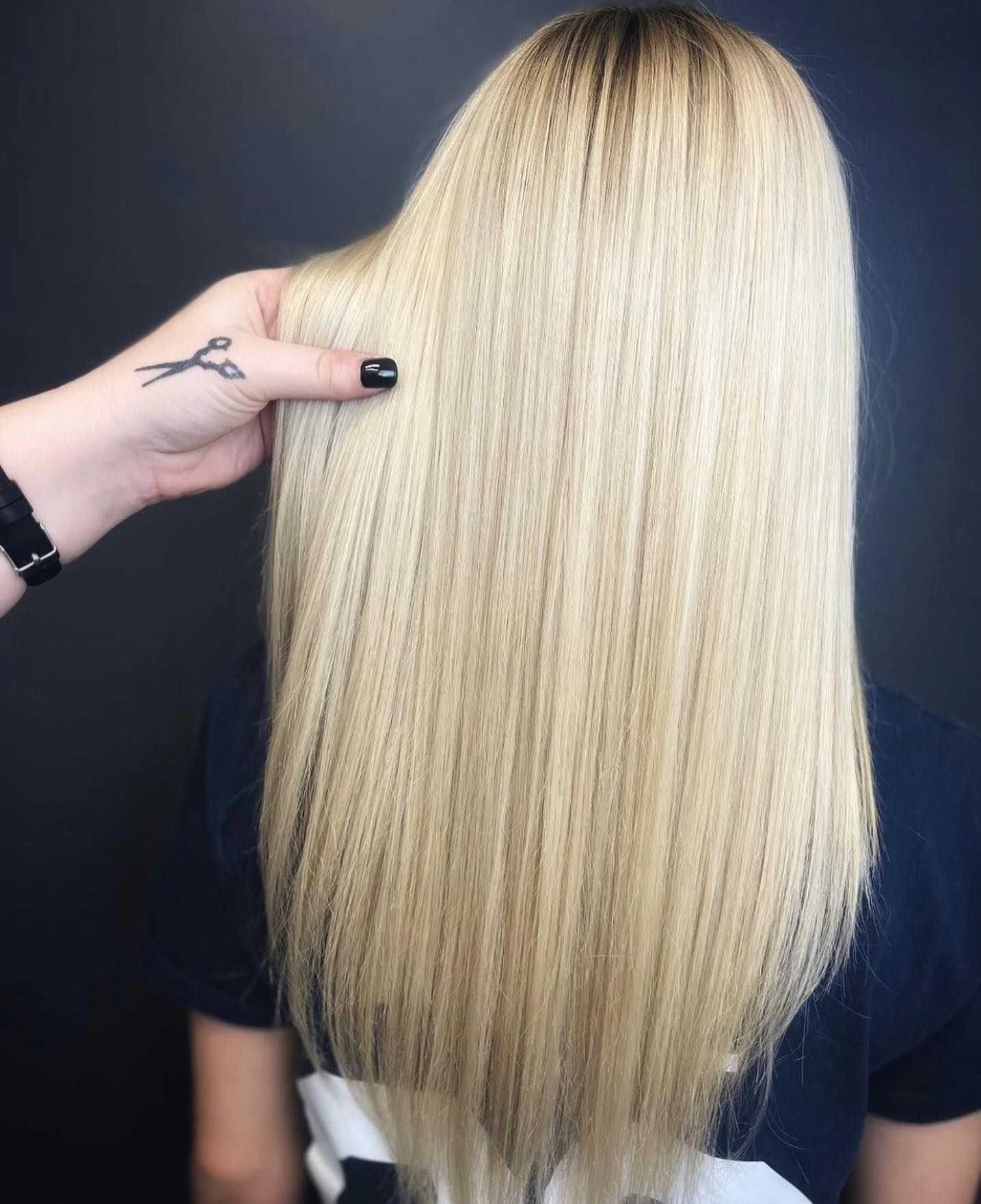 Hairdresser showing freshly straightened, smooth, blonde hair from the back.