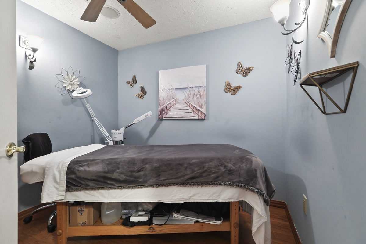 Massage room with a treatment table, soft lighting, wall art, and a cozy ambiance.